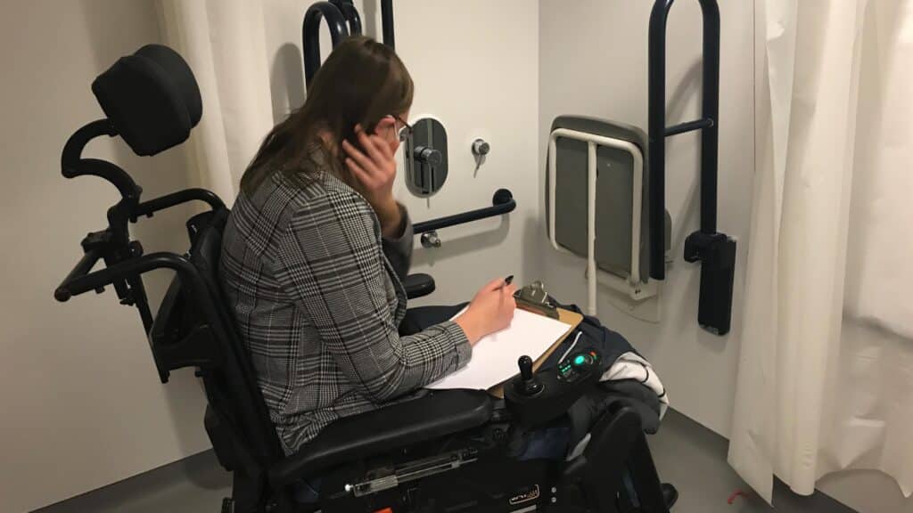 Woman in wheelchair assessing Disabled toilet